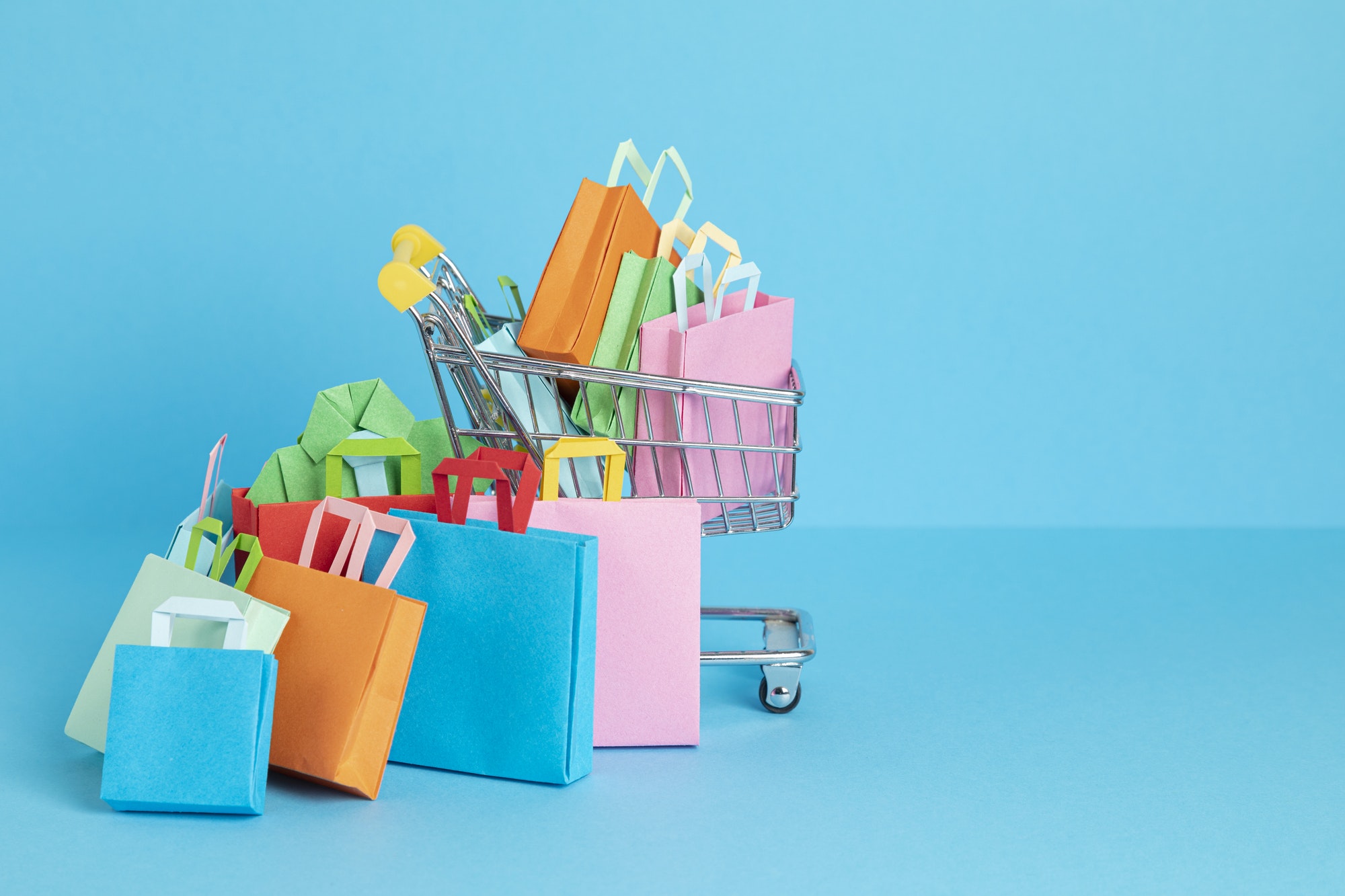 Shopping basket full of paper bags. Sesonal sale, online deals, discounts, promotions idea