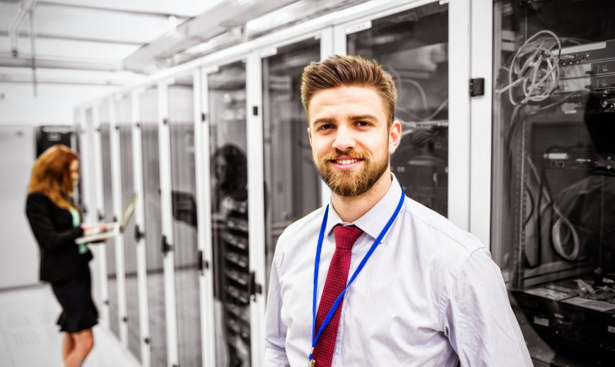 Smiling technician standing in a server room