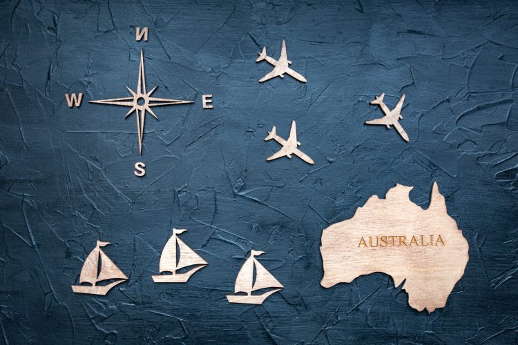 Wooden figurines on the theme of travel to Australia on a textured background.
